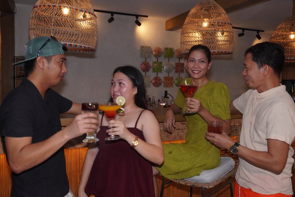 Four friends raising cocktails together in Salsa's dining room.