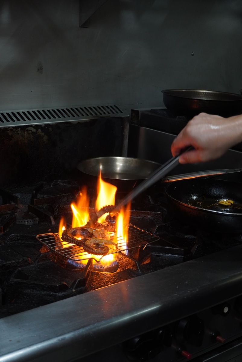 Flames leaping from a pan on the grill in Salsa's kitchen.